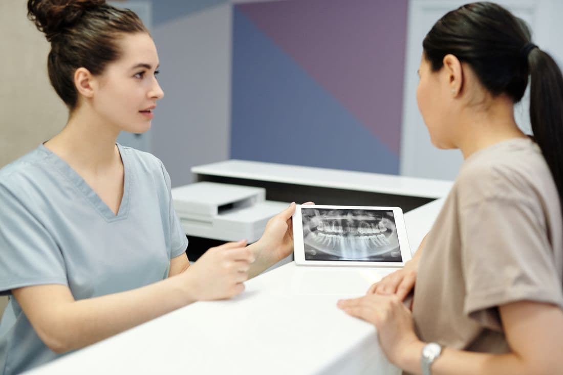 A hygienist talking a patient through their X-ray
